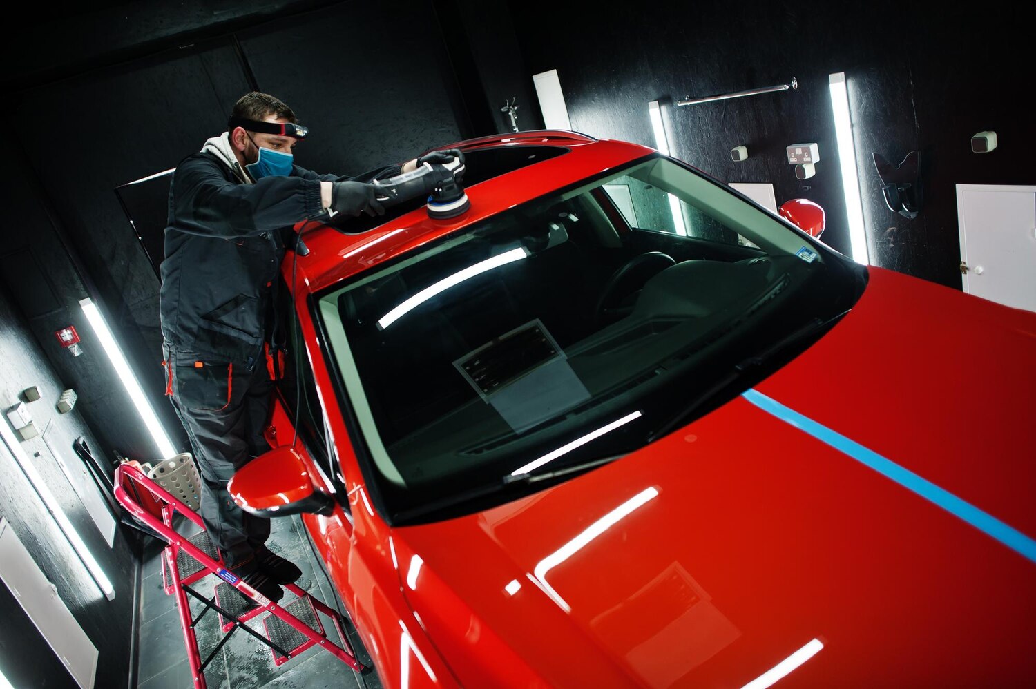 car-detailing-concept-man-face-mask-with-orbital-polisher-repair-shop-polishing-roof-orange-suv-car_627829-12612